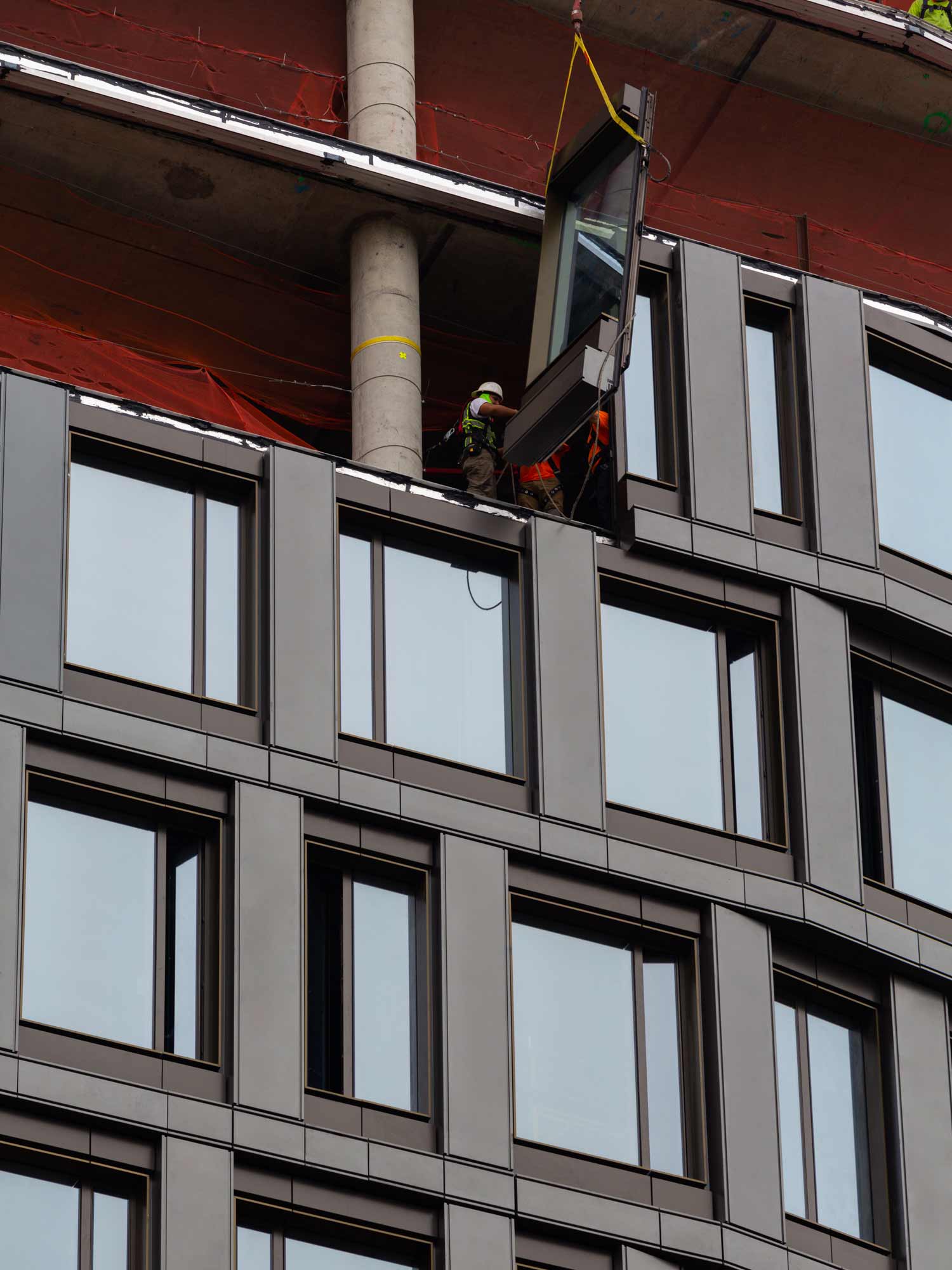 Workers installing a window on Olympia Dumbo.